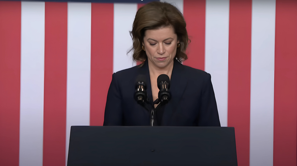 Executive Director Giovanna Gray Lockhart stands behind a podium at the Department of Labor, delivering remarks.